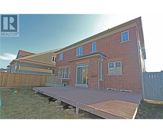 A red brick house with a wooden deck in front.