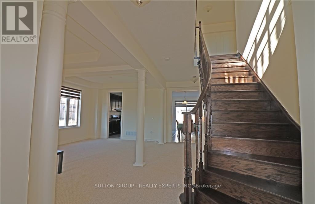 A staircase in a house with a logo of a realtor on the top left.