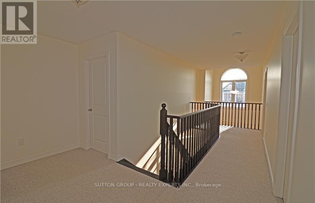 A spacious room with a carpeted floor and a balcony with a railing.