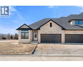 A house with a brown brick exterior and a black roof is for sale.