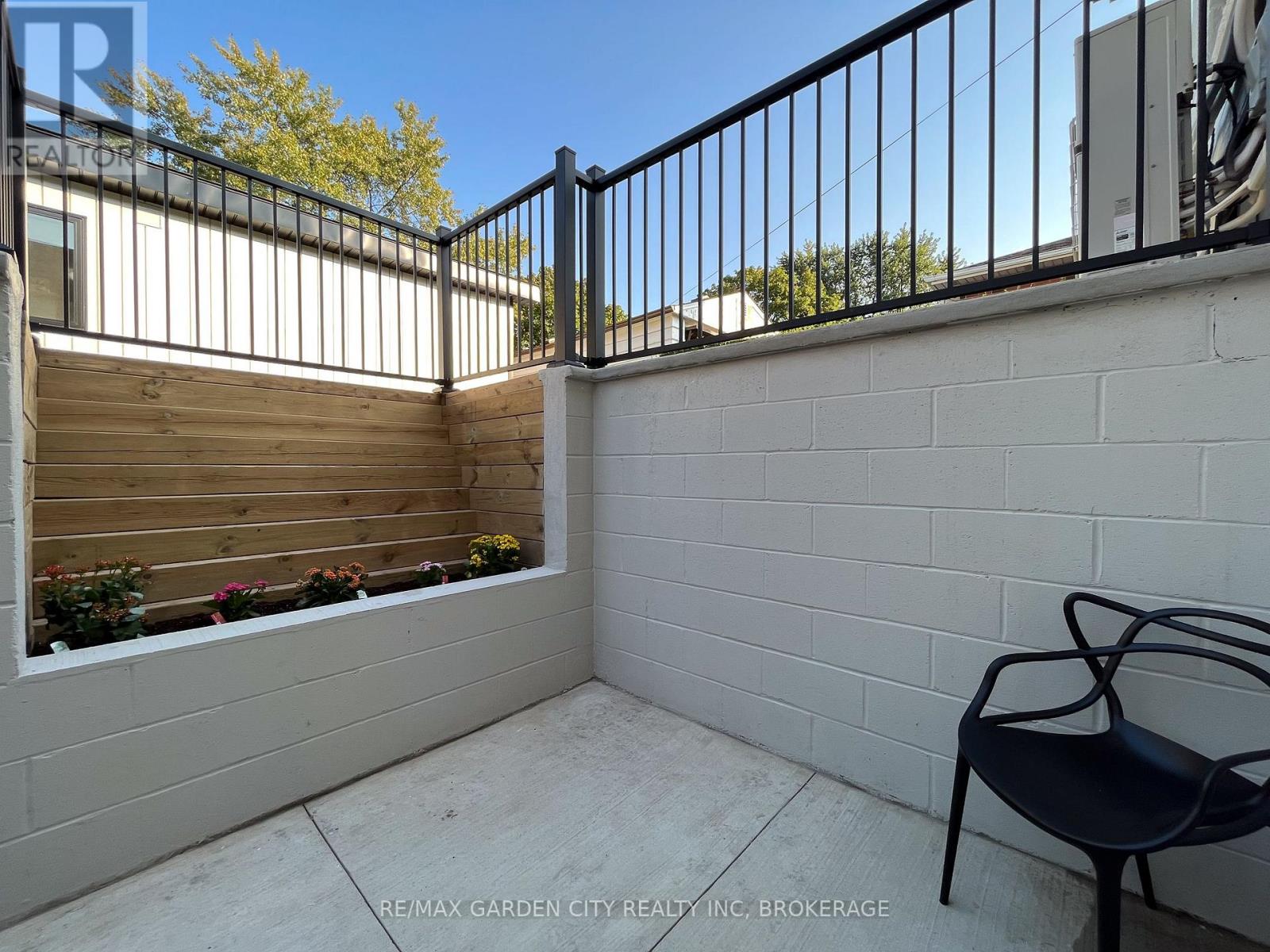 A balcony with a black metal railing and a black chair.