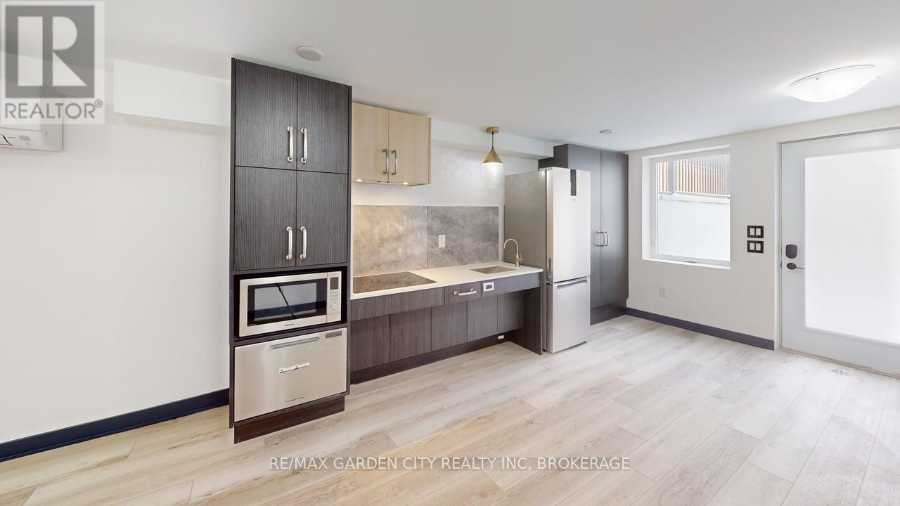 A modern kitchen with a refrigerator, oven, and cabinets.