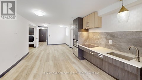 A kitchen with a sink and a refrigerator.