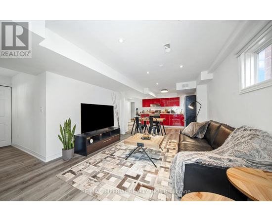 A living room with a brown leather couch and a wooden floor.