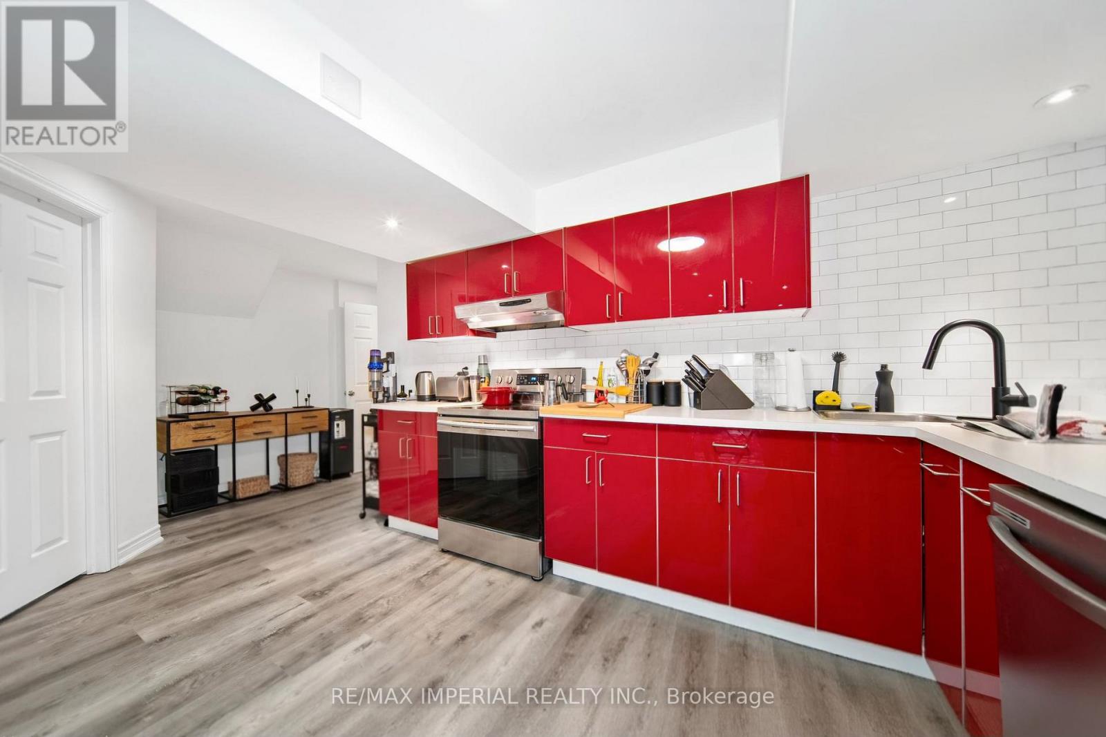 A kitchen with red cabinets and a white countertop.