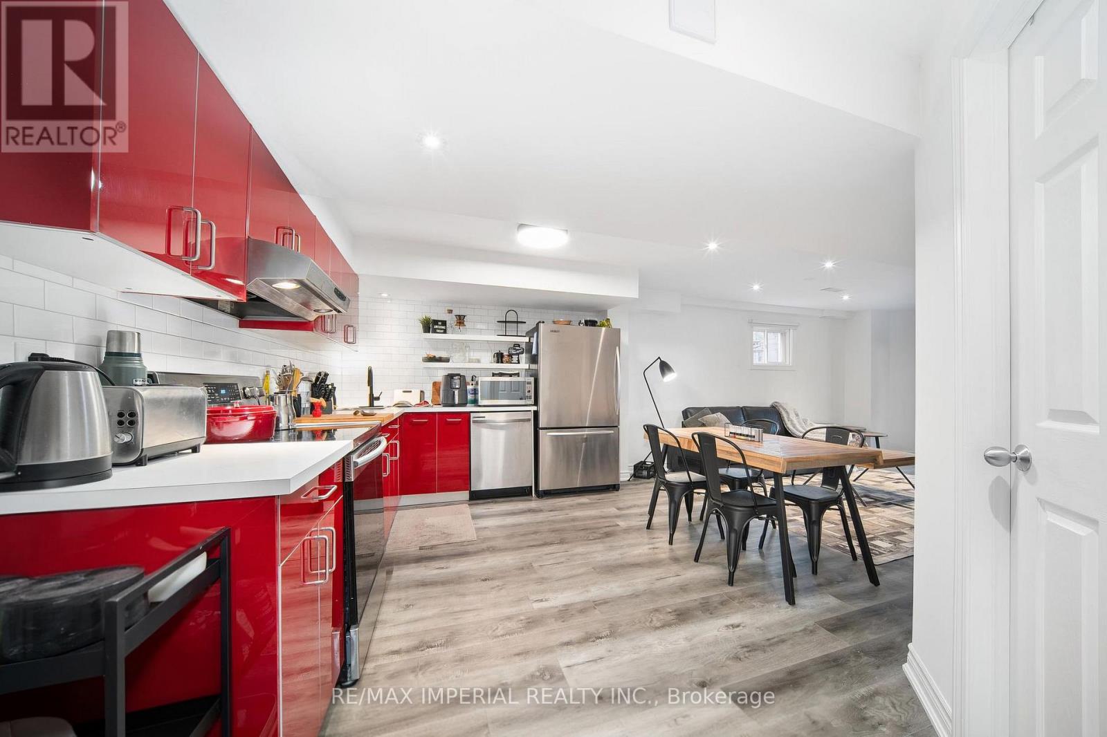 A kitchen with red cabinets and a dining table.