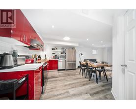A kitchen with red cabinets and a dining table.