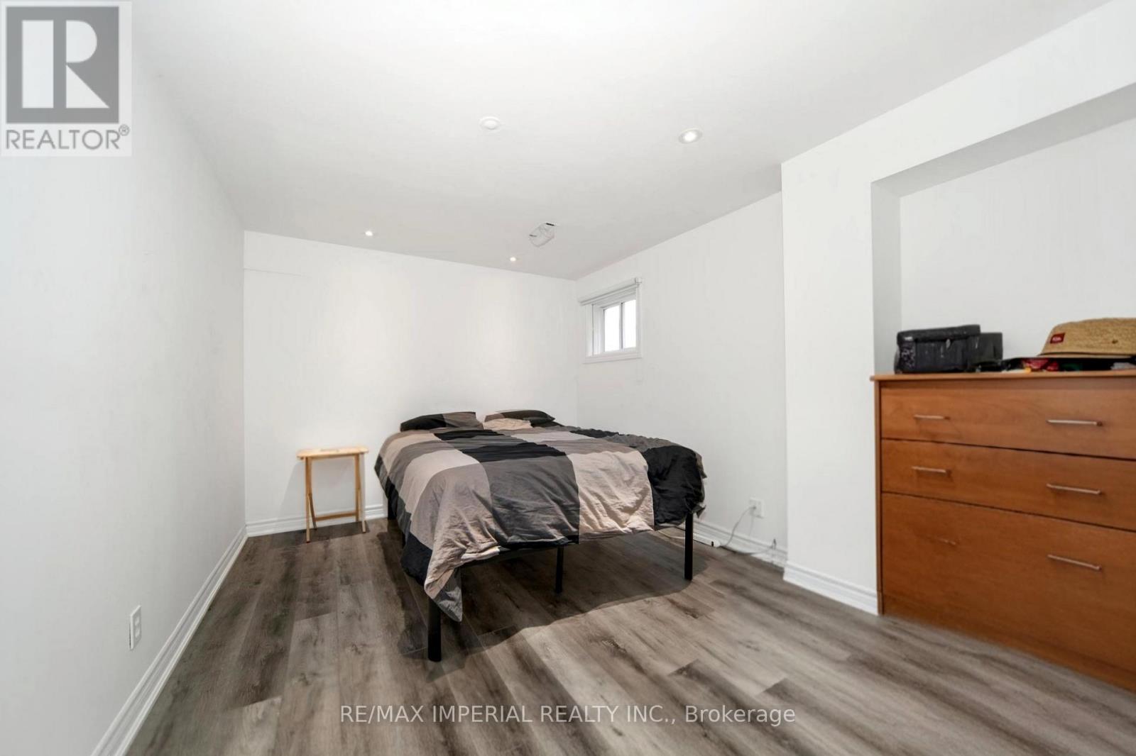 A bedroom with a bed, dresser, and nightstand.
