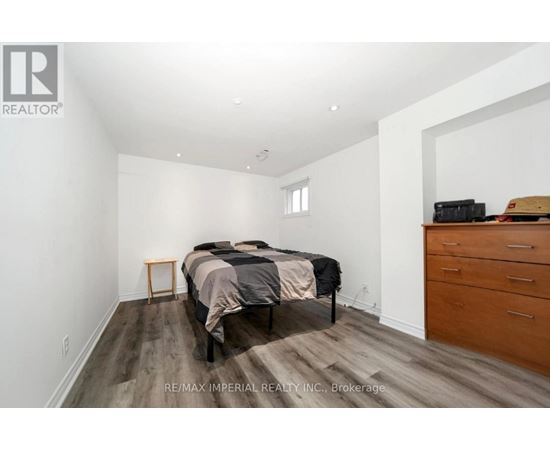 A bedroom with a bed, dresser, and nightstand.