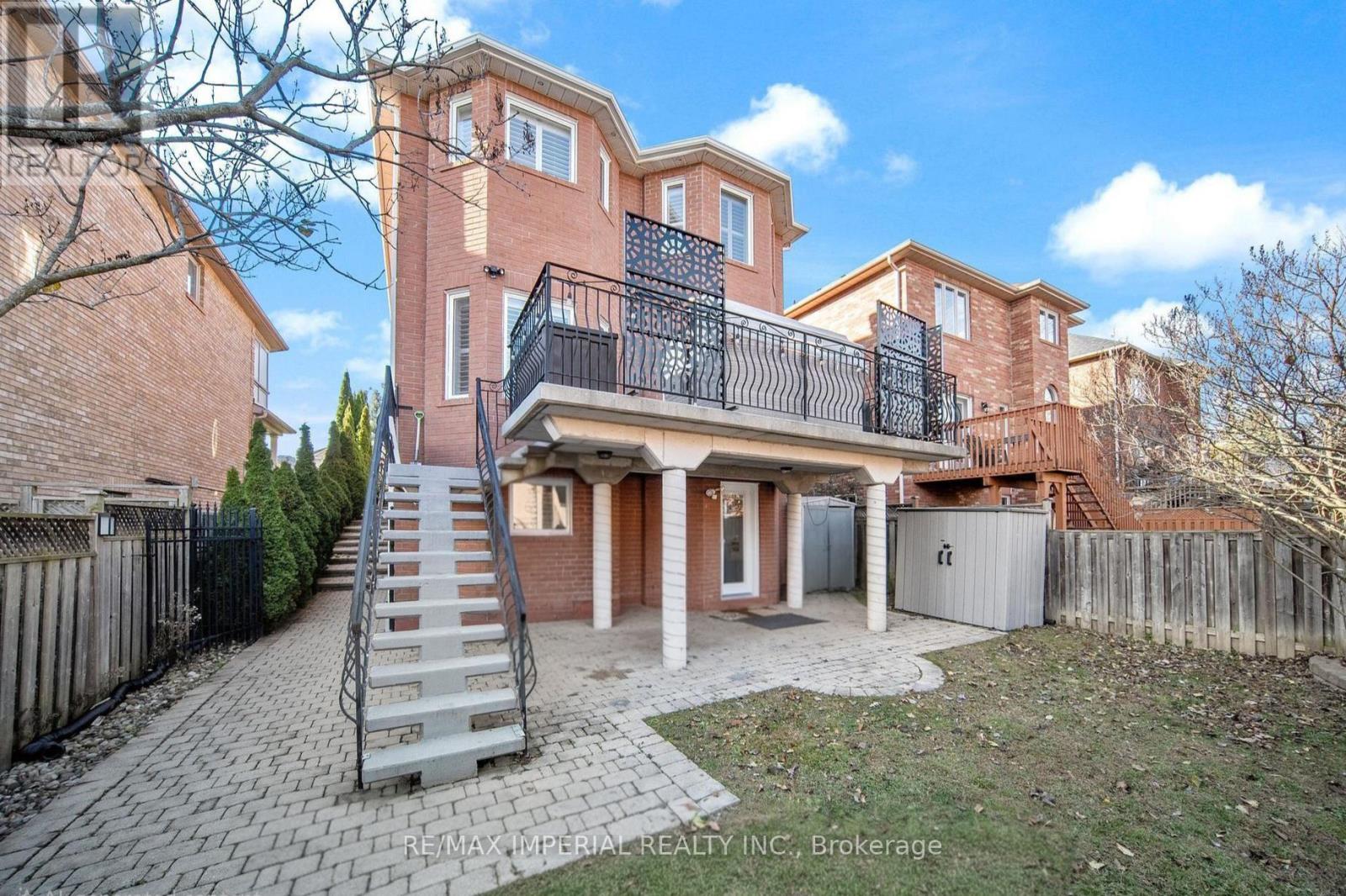 A large brick house with a balcony and a staircase leading to the entrance.
