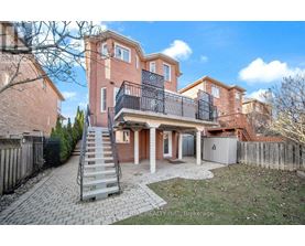A large brick house with a balcony and a staircase leading to the entrance.