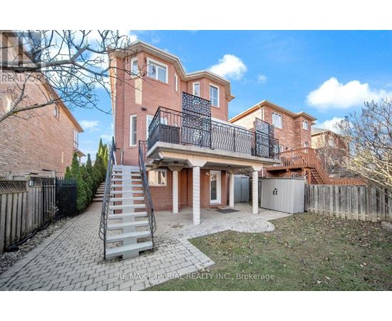 A large brick house with a balcony and a staircase leading to the entrance.