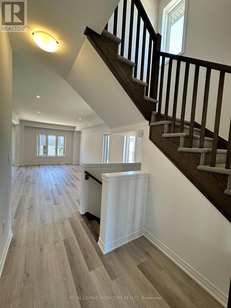 A spacious hallway with a staircase and a window.