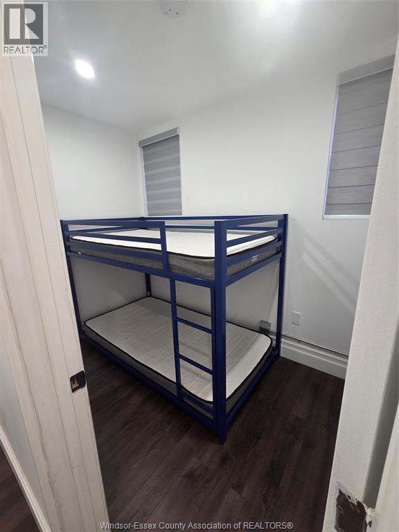 A blue metal bunk bed in a white room.