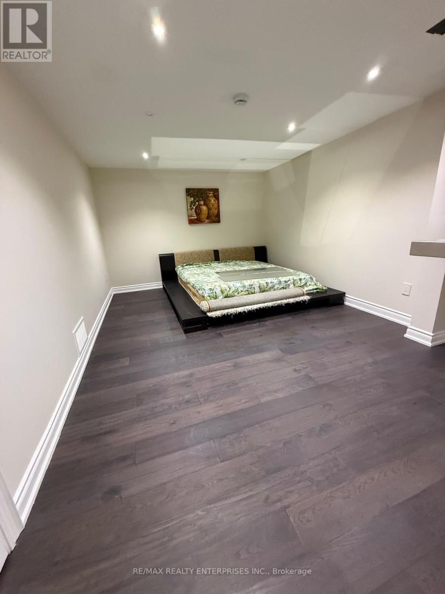 A bedroom with a bed in the middle and a painting on the wall.