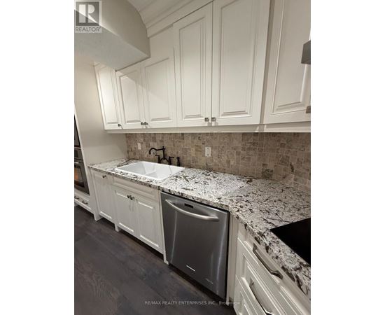 A kitchen with white cabinets and a granite countertop.