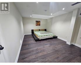 A room with wooden flooring and a window letting in sunlight.