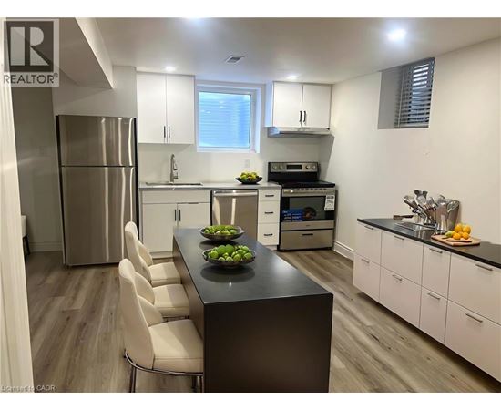 A modern kitchen with a black island and white cabinets.