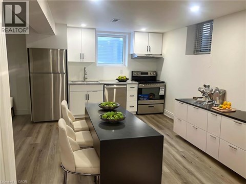 A modern kitchen with a black island and white cabinets.