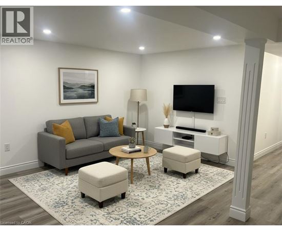 A living room with a grey couch, a coffee table, a lamp, a TV, and a framed picture on the wall.
