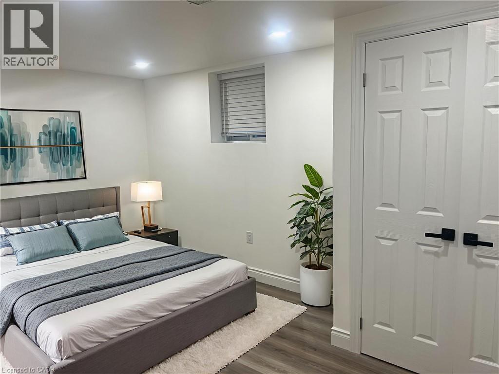 A bedroom with a bed, a lamp, and a plant.
