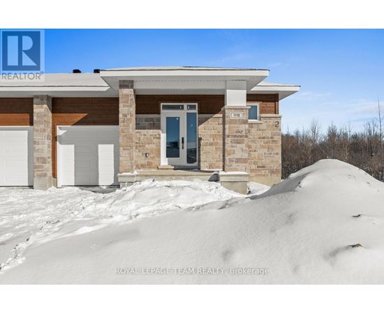 A house with a large mound of snow in front of it.