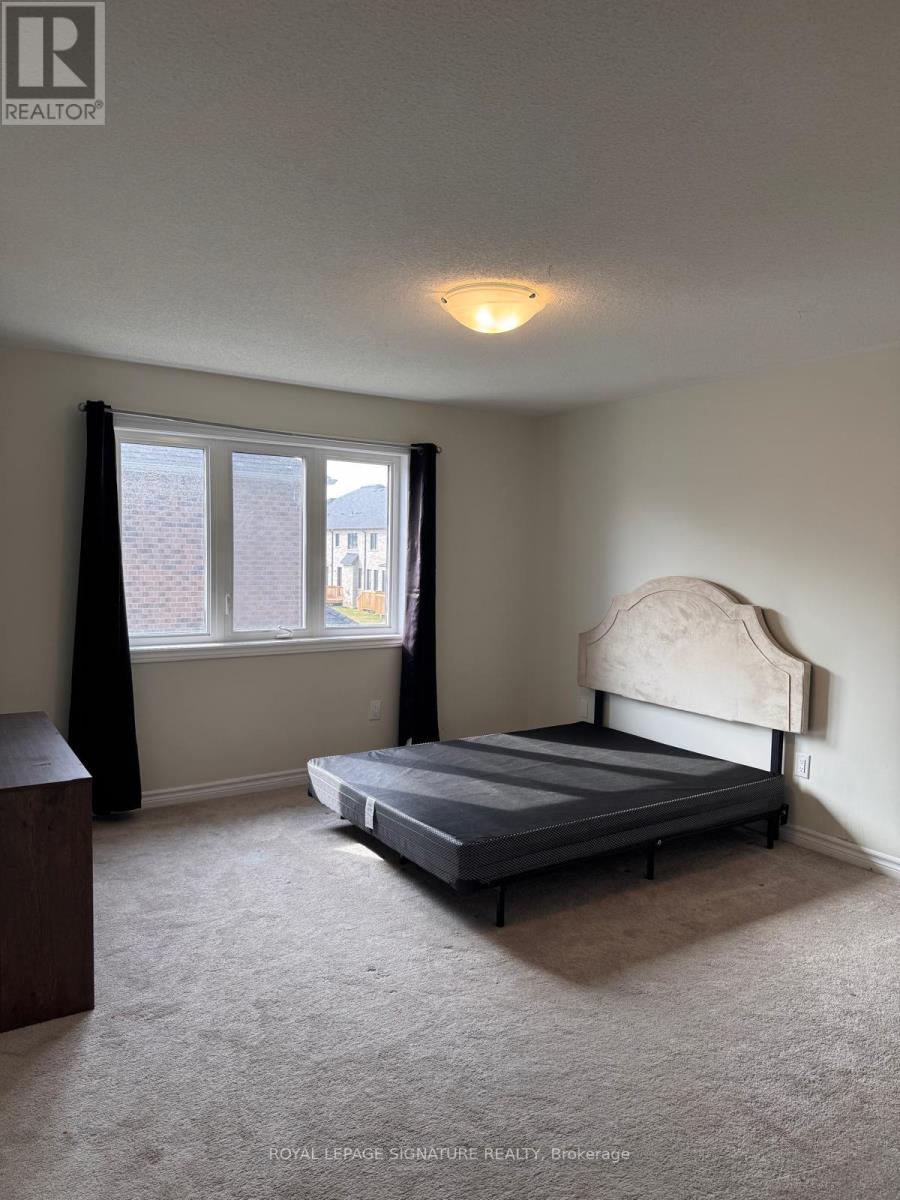 A bedroom with a bed, nightstand, and window.