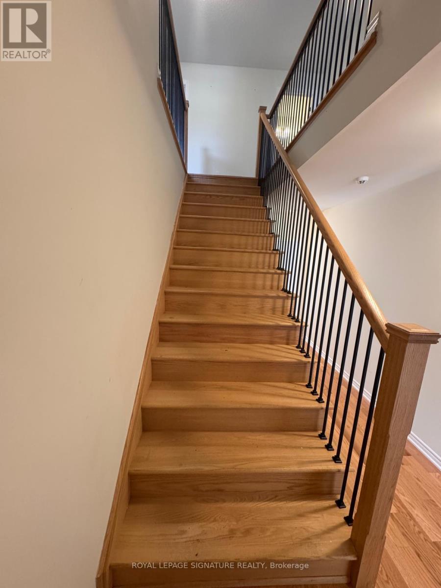 A wooden staircase with a black railing.