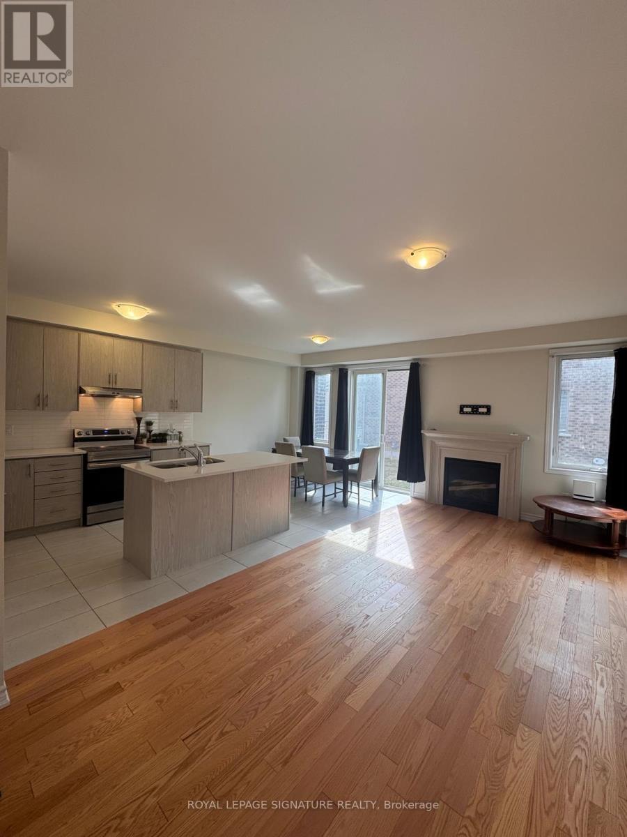 A well-lit, spacious kitchen and living room with wooden flooring and modern appliances.