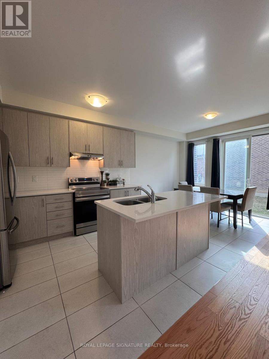 A kitchen with a refrigerator, sink, and cabinets.