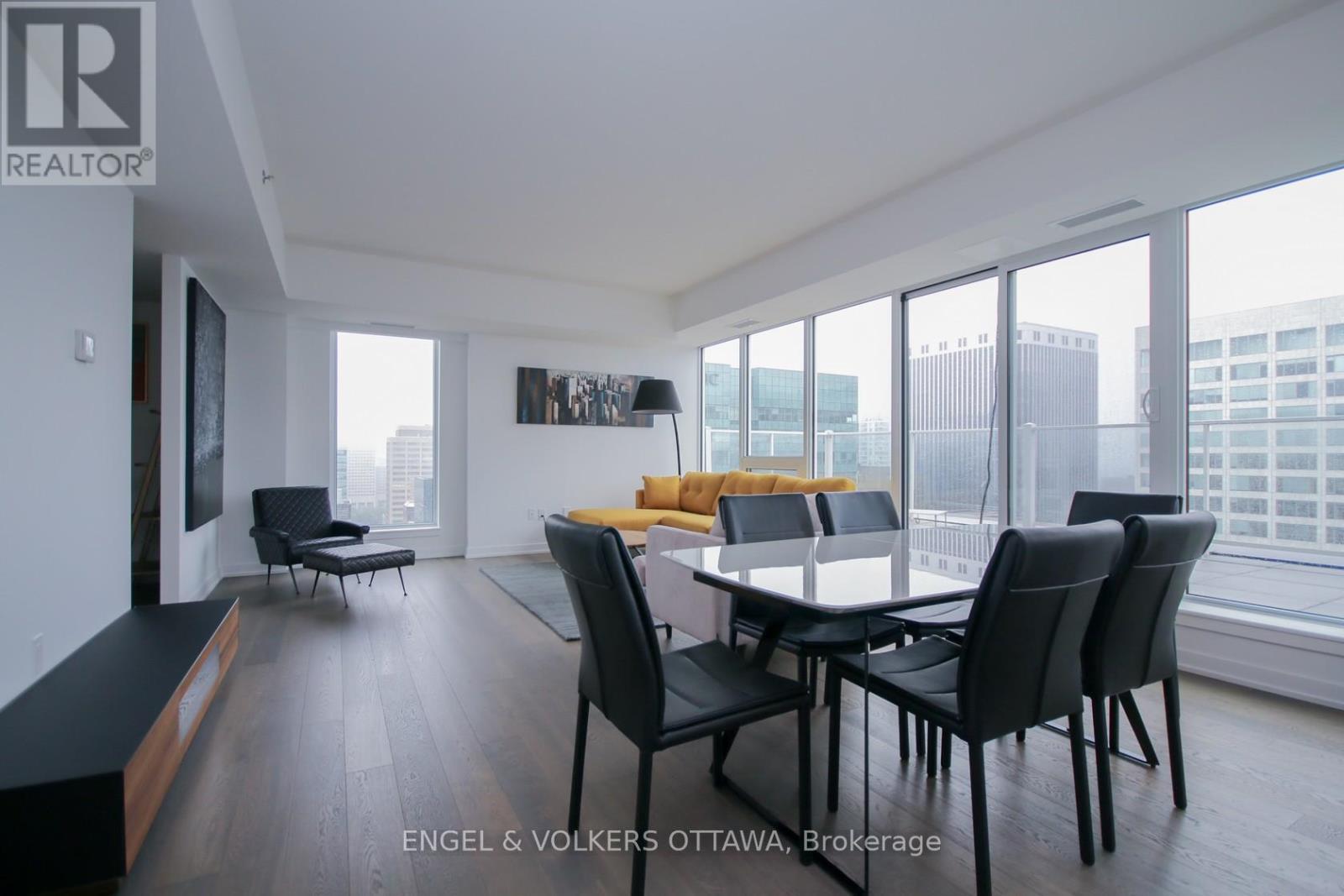 A modern dining room with a large table and chairs.