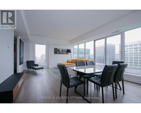 A modern dining room with a large table and chairs.