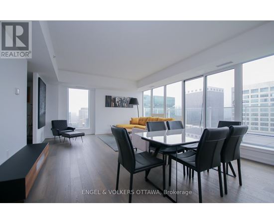 A modern dining room with a large table and chairs.