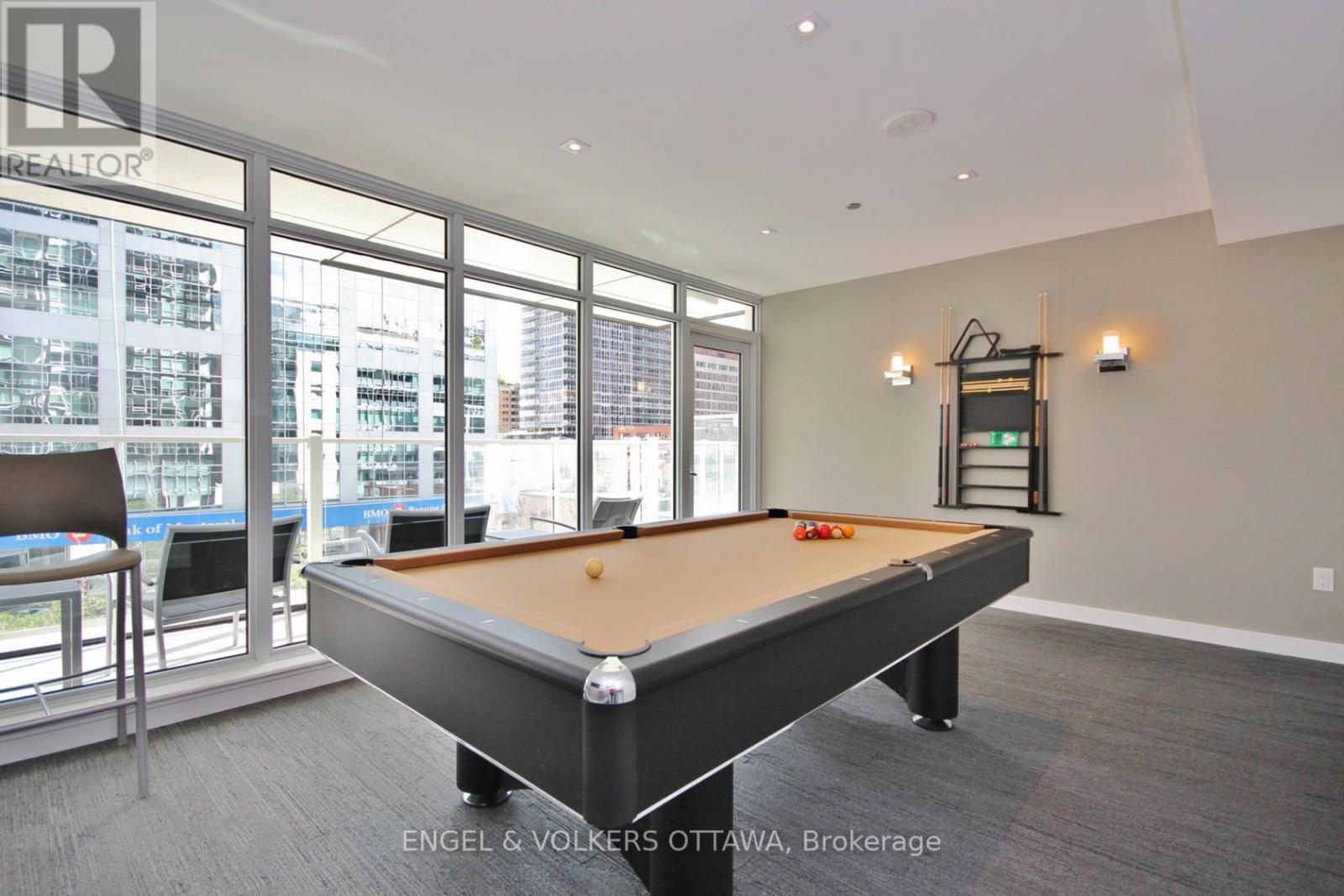 A pool table in a room with a view of the city.