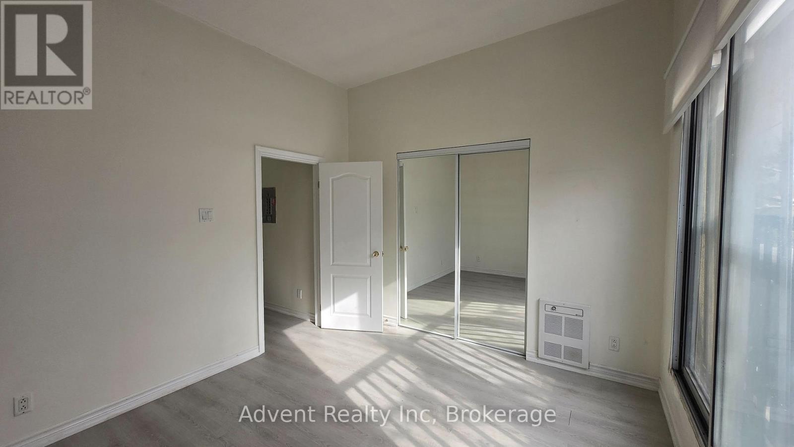 A room with a white door and a window with sunlight coming through.