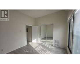 A room with a white door and a window with sunlight coming through.
