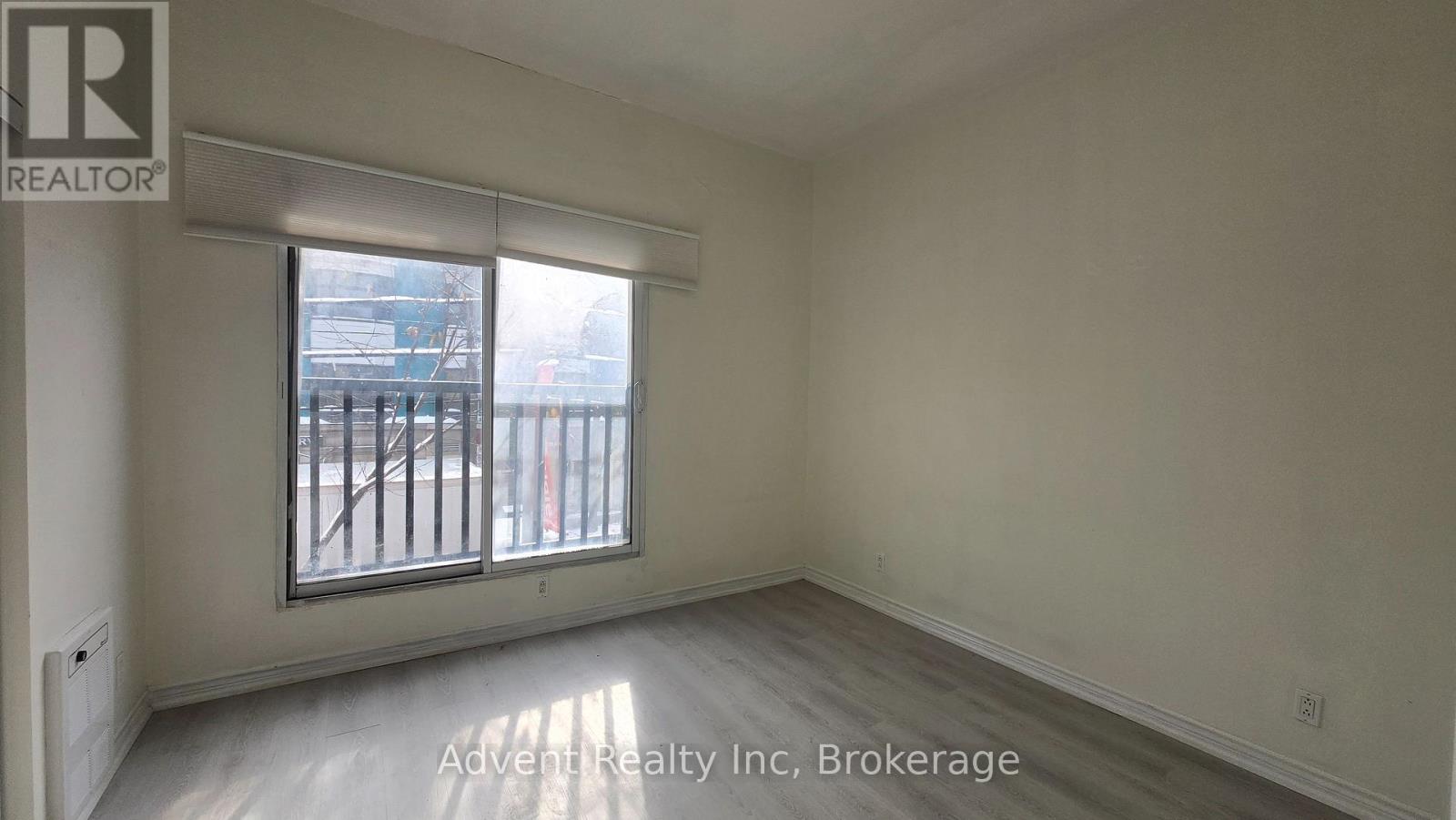 A room with a window and a sign that says Advent Realty Inc Brokerage.
