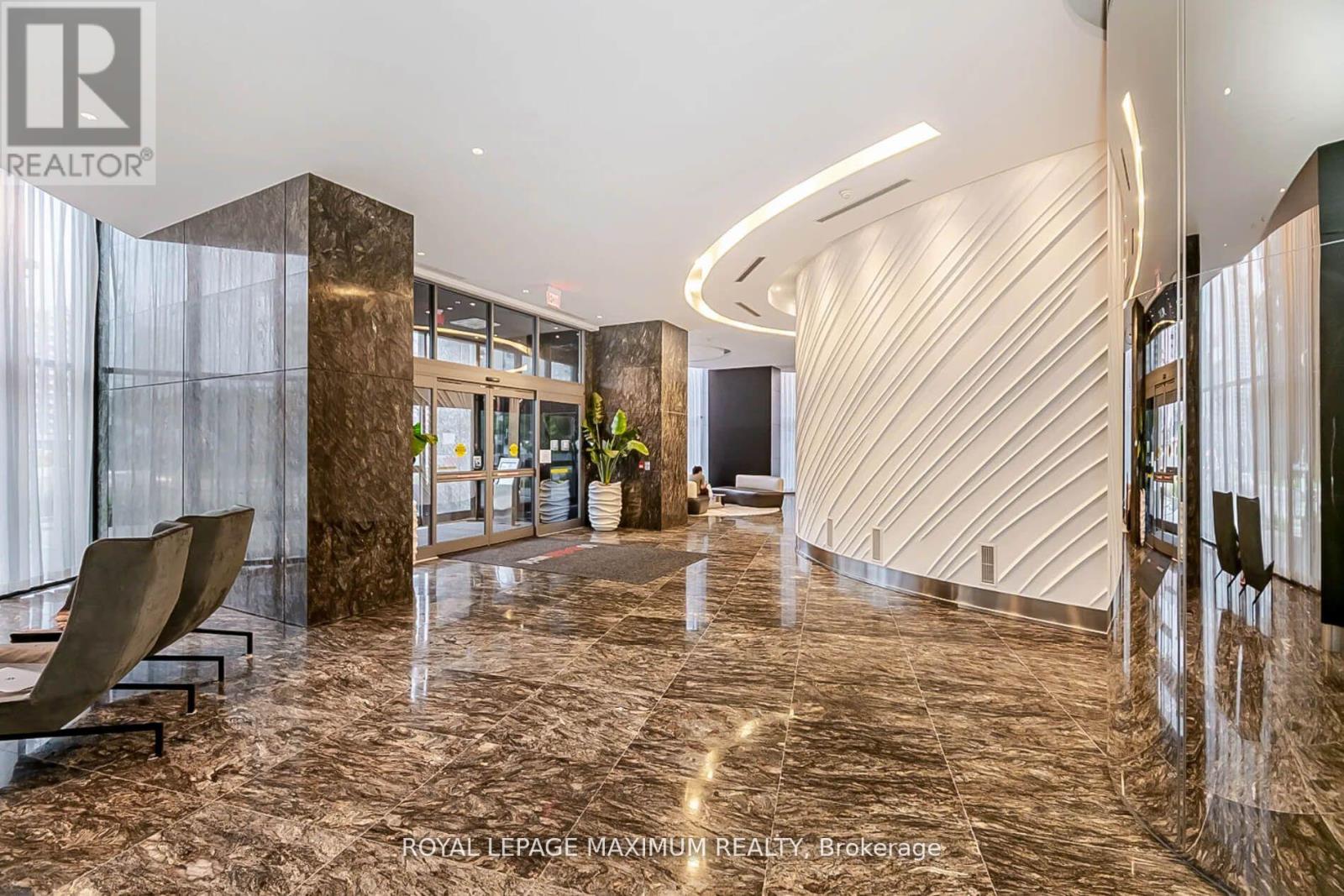 A spacious lobby with marble floors and a modern design.