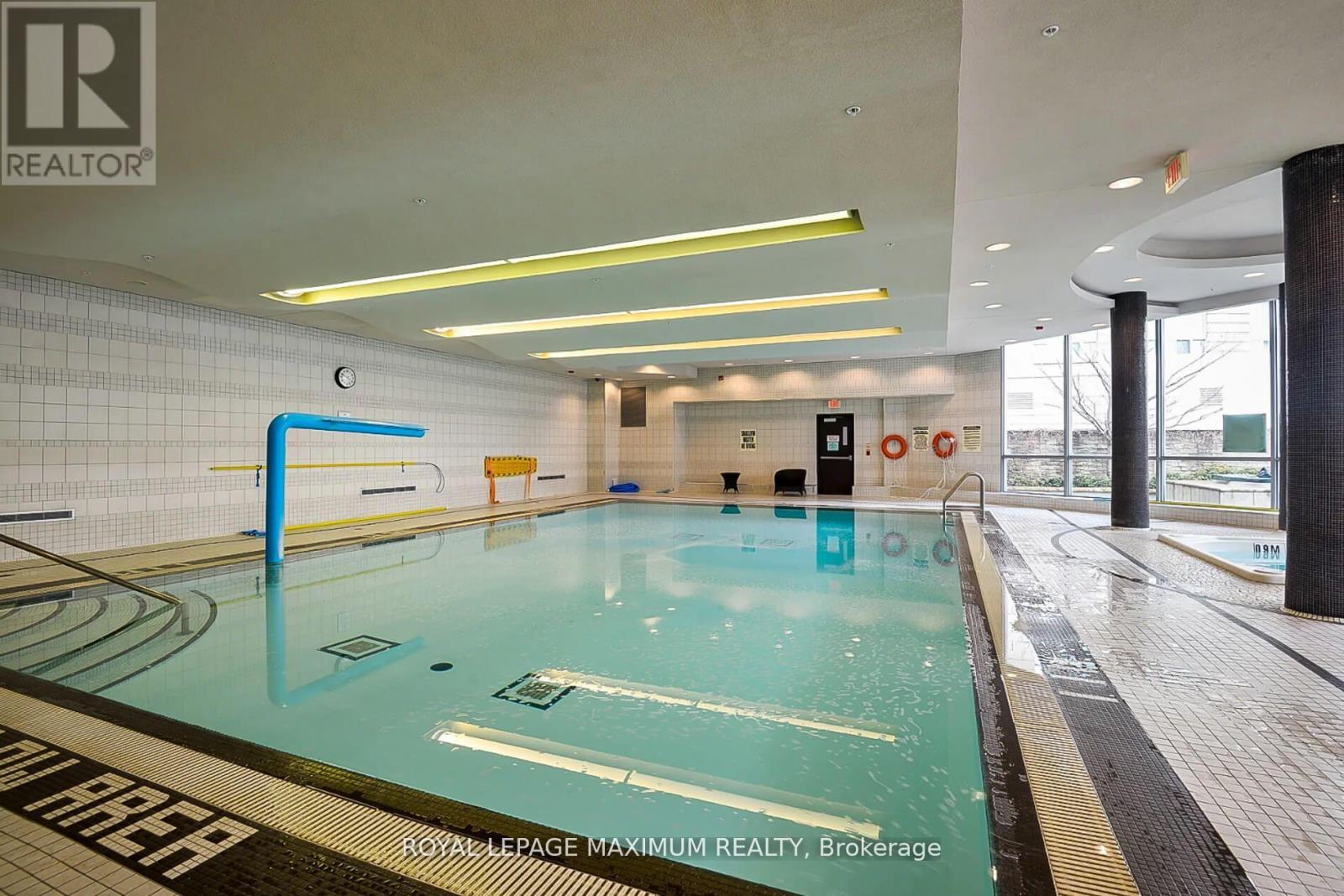 A swimming pool inside a building with a sign that says "REALTOR".