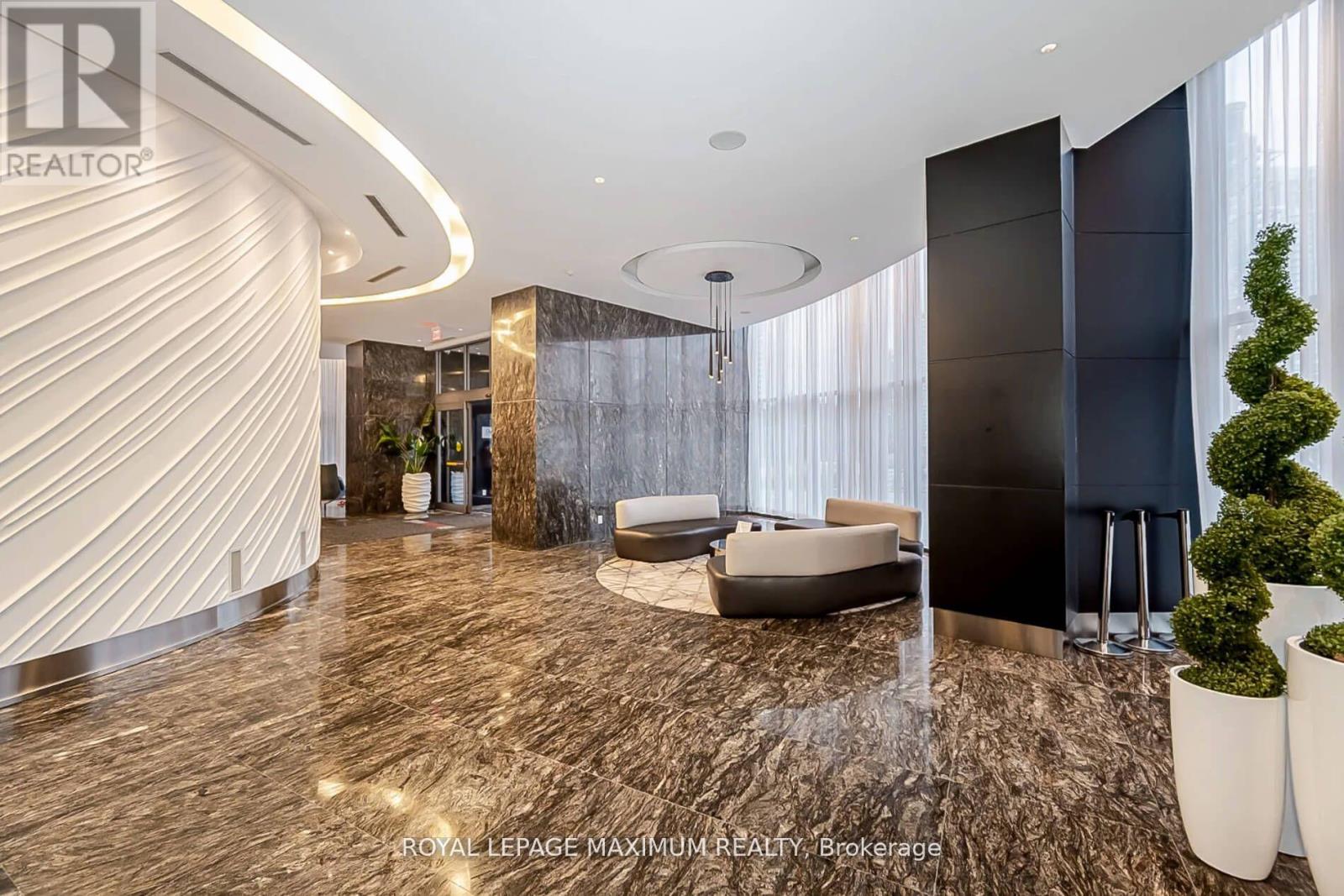 A modern living room with a curved white wall and a dark wood floor.
