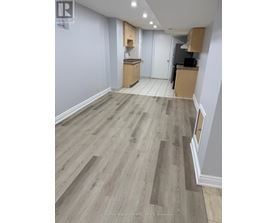A room with wooden flooring and a white door.