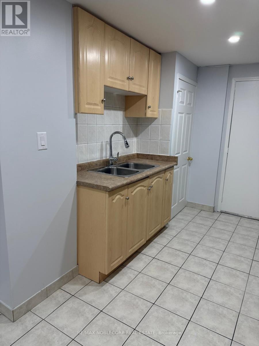 A kitchen with wooden cabinets and a tiled floor.