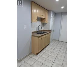 A kitchen with wooden cabinets and a tiled floor.
