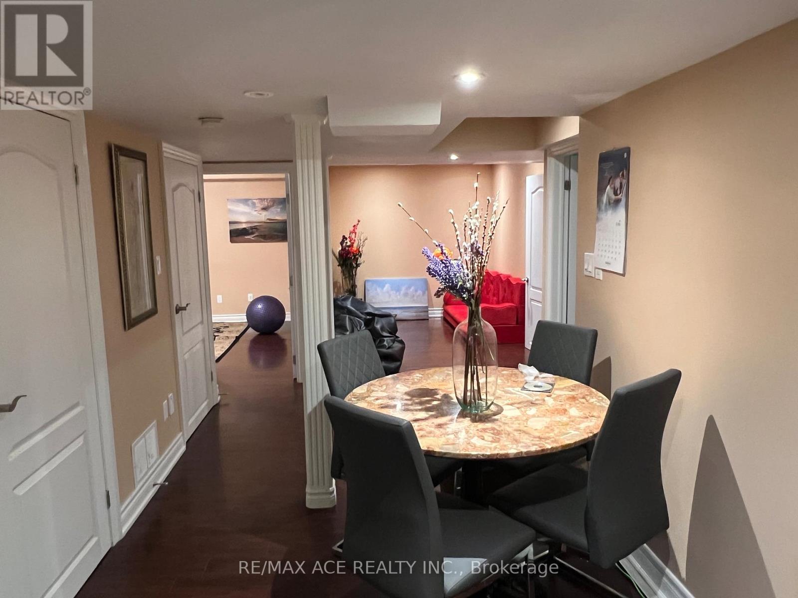 A dining room with a round table and chairs.