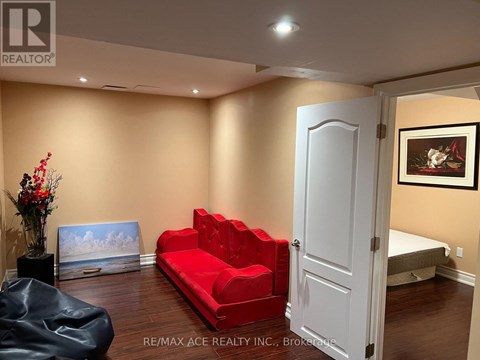 A living room with a red couch and a black chair.