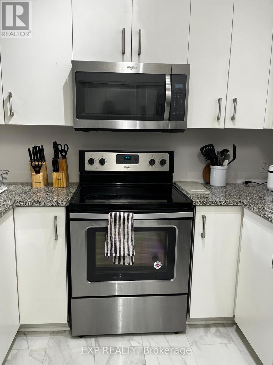 A modern kitchen with a stove top oven and microwave above it.