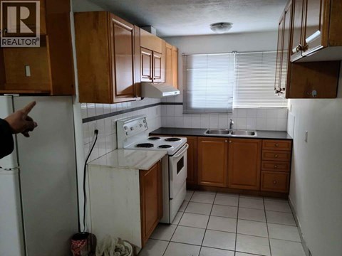 A kitchen with a white stove top oven and a white dishwasher.