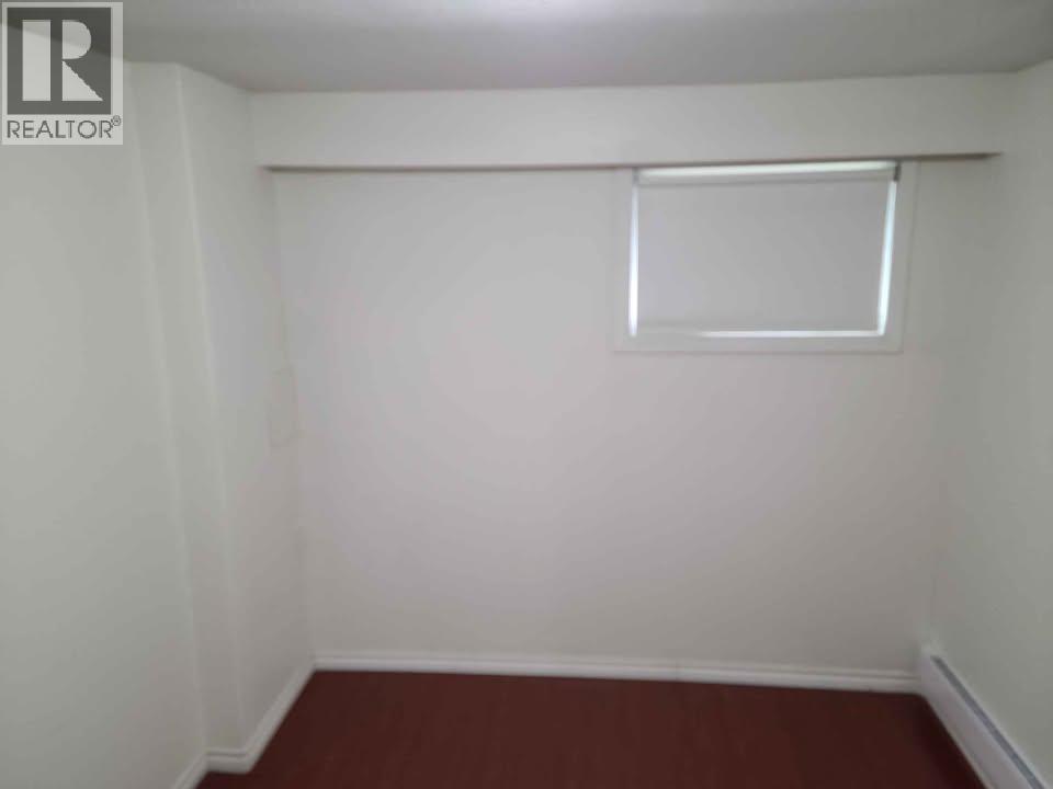 A small room with a window and a brown floor.