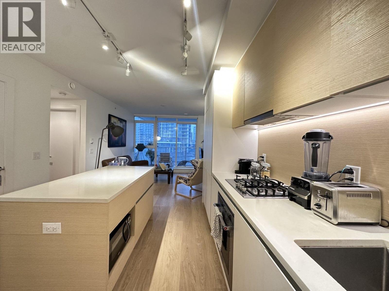 A modern kitchen with a long counter and a window.