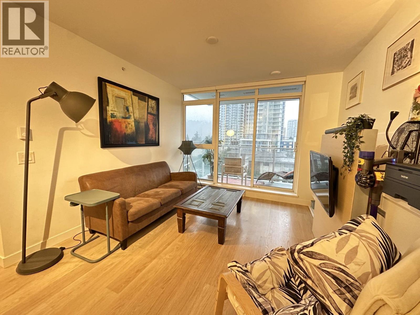 A living room with a brown couch and a lamp.